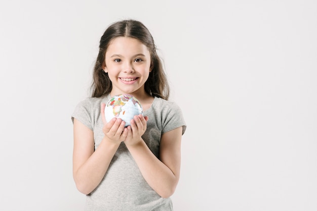 Kostenloses Foto nettes mädchen mit kugel im studio