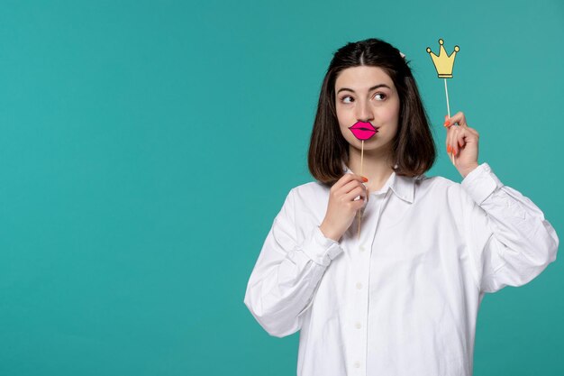 Nettes Mädchen reizendes junges hübsches Brunettemädchen im weißen Hemd, das oben mit Krone und Lippen schaut