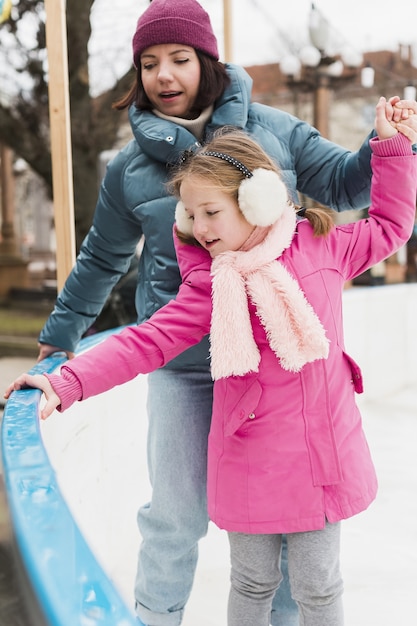 Nettes Mädchen und Mutter Eislaufen