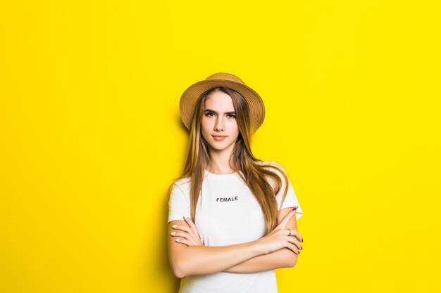 Nettes Modell im weißen T-Shirt und im Hut unter orange Hintergrund mit lustigem Gesicht