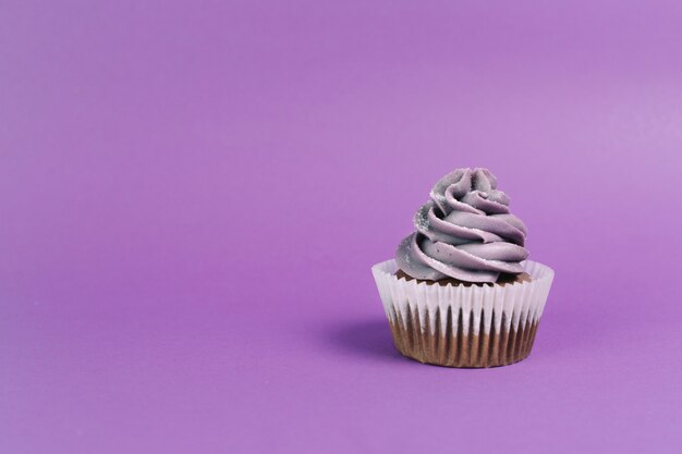 Nettes Muffin auf violettem Hintergrund