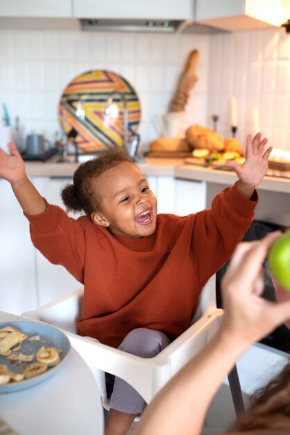 Nettes schwarzes Baby, das sich zu Hause amüsiert