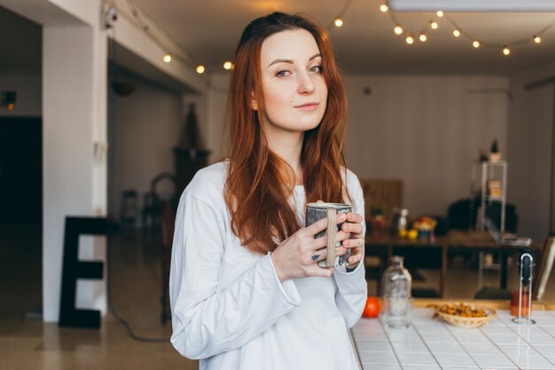 Nettes und hübsches Teenagerporträt, das Kaffee trinkt