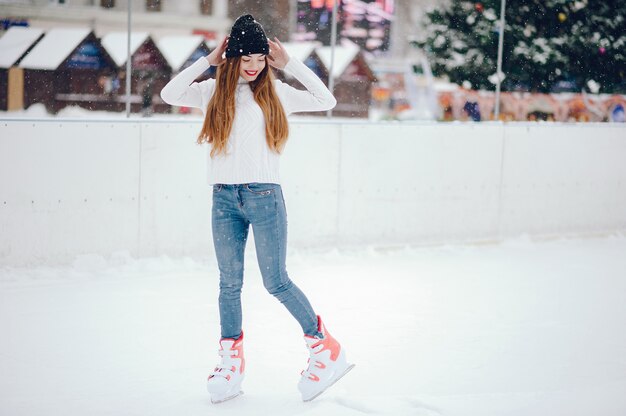 Nettes und schönes Mädchen in einer weißen Strickjacke in einer Winterstadt