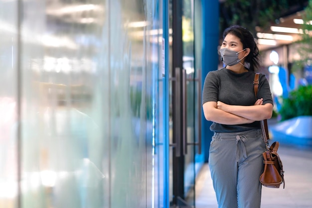 Neue Normalität nach einer Covid-Epidemie Junge asiatische Geschäftsfrauen tragen eine Gesichtsschutzmaske, die im Kaufhauszentrum auf dem Center Square spaziert Neuer Lebensstil nach der Ausbreitung des Corona-Virus covid19