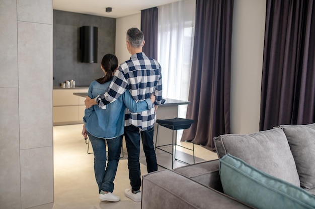 Neues Haus Rückansicht von Mann und Frau, die Schlüssel in der Hand halten und in einem neuen modernen Haus stehen