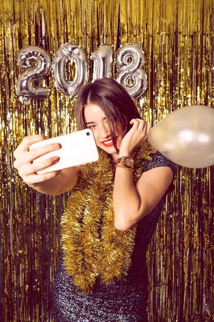 Kostenloses Foto neues jahr-konzept mit lächelnden mädchen, die selfie nehmen