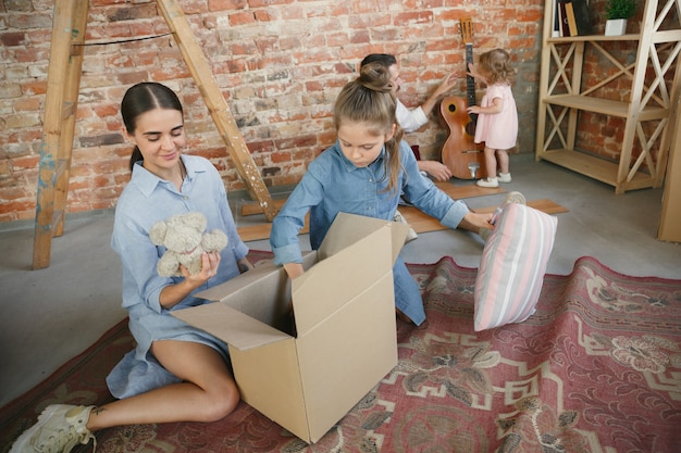 Neues Leben. Erwachsene Familie zog in ein neues Haus oder eine neue Wohnung. Ehepartner und Kinder sehen glücklich und selbstbewusst aus