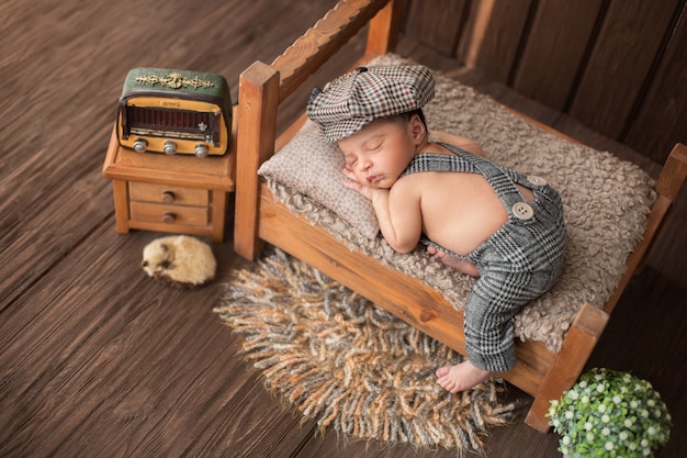 Neugeborenes Baby, das in einem schönen Raum schläft, der Teppichblumenradio und niedliches Tier einschließt