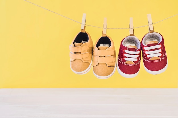 Neugeborenes Konzept mit zwei Schuhen auf Wäscheleine