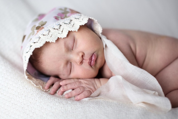 Neugeborenes schläft auf hellem Hintergrund des Bauches im wirklichen Leben