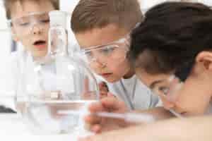 Kostenloses Foto neugierige kinder machen ein chemisches experiment in der schule experiment