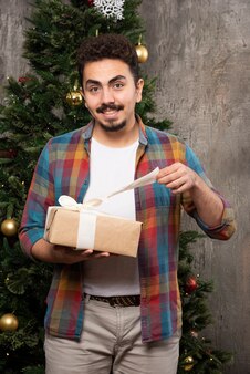 Neugieriger mann mit geschenkgutschein für die weihnachtszeit