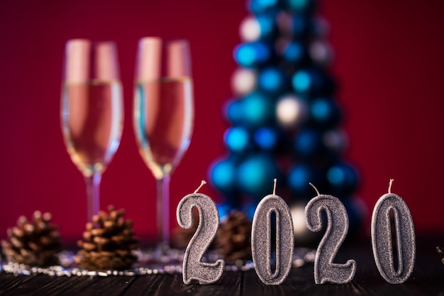 Neujahr 2020 Komposition mit Champagner und Platz für Text gegen verschwommene Weihnachtslichter und Baum. Neujahrs- und Weihnachtskonzept