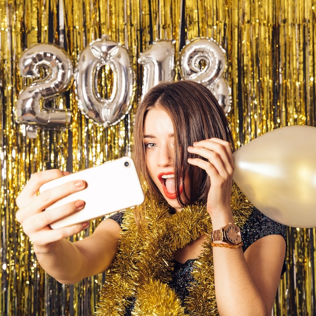 Kostenloses Foto neujahr party-konzept mit mädchen mit smartphone