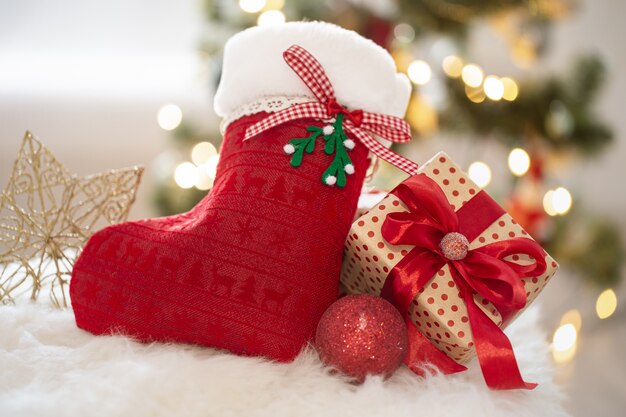 Neujahrsfeiertagshintergrund mit einer dekorativen Socke und Geschenkbox in einer gemütlichen häuslichen Atmosphäre hautnah.