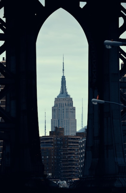 Kostenloses Foto new york city, ny - 11. juli: empire state building über manhattan bridge am 11. juli 2014 in new york city. es ist ein 102-stöckiges wahrzeichen und war mehr als 40 jahre lang das höchste gebäude der welt.