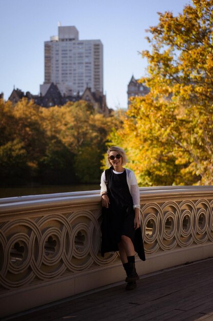 New York Manhattan Central Park im Herbst, Brücke über den See. junge Frau geht in einem Herbstpark in New York spazieren.