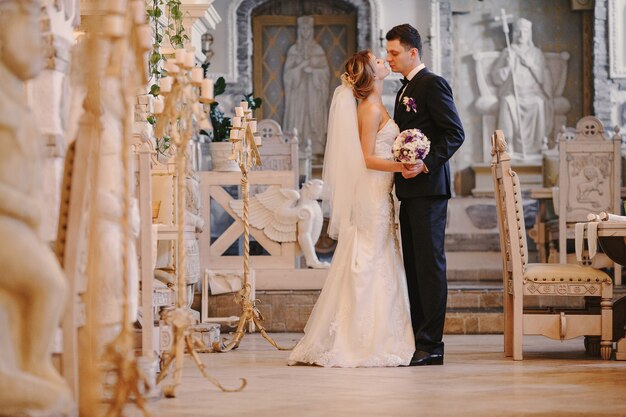 Newlyweds kissing in der Kirche