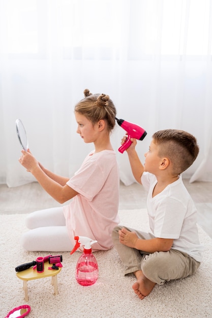 Kostenloses Foto nicht binäre kinder, die ein schönheitssalonspiel spielen