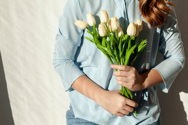 Nicht erkennbare Frau, die Tulpen hält