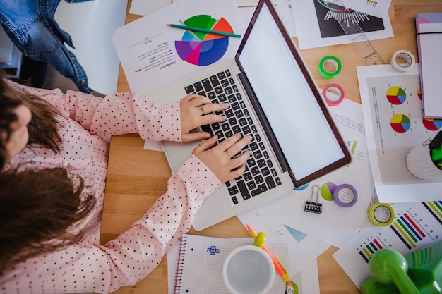 Nicht erkennbare Frau schreibt Laptop im Büro