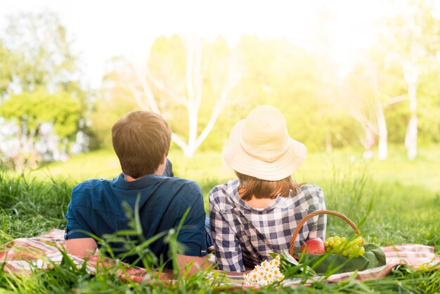 Nicht erkennbare Paare, die auf Plaid im Wald liegen