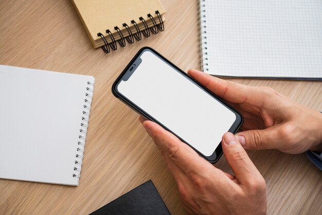 Kostenloses Foto nicht erkennbarer mann, der leeres telefon hält