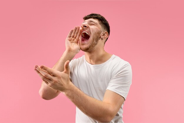 Nicht verpassen. Junger lässiger Mann, der schreit. Schreien. Weinender emotionaler Mann, der auf rosa Studiohintergrund schreit. männliches Porträt in halber Länge. Menschliche Emotionen, Gesichtsausdruckkonzept. Trendige Farben