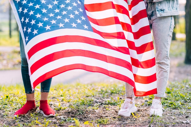 Kostenloses Foto nicht wiedererkennbare frauen, die usa-flagge am vierten juli halten