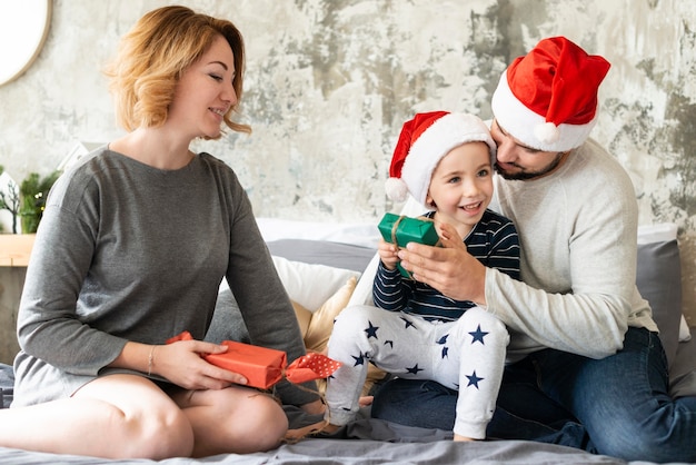 Niedliche Familie der Vorderansicht, die zusammen am Weihnachtstag ist