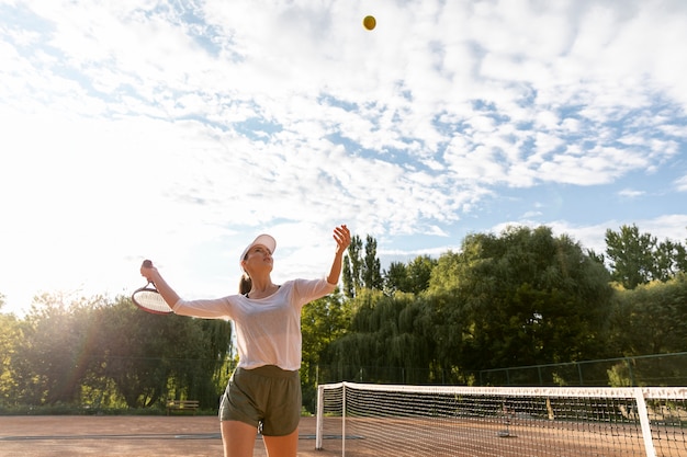 Niedrige Ansichtfrau, die während des Tennismatches dient