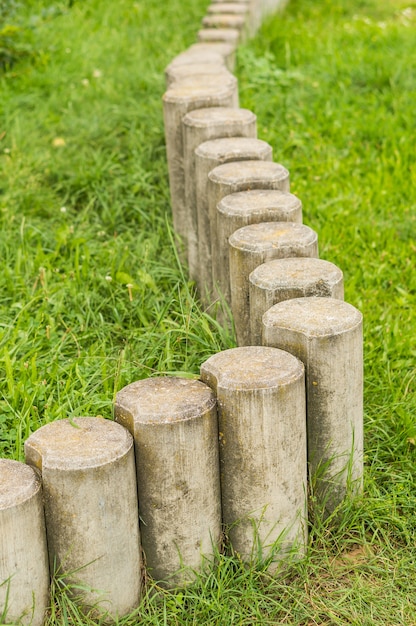 Niedrige steinpfostenbarriere auf grünem gras im weichzeichner