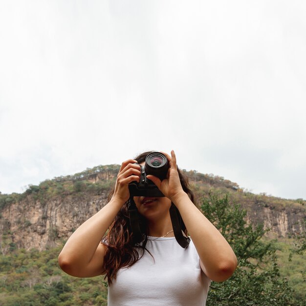 Niedrige Winkelfrau, die Fotos mit Kopieraum macht