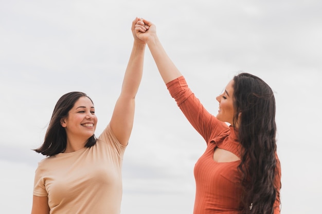 Niedrige winkelfrauen, die hände halten