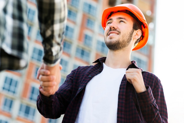 Niedrige Winkelsicht der Nahaufnahme des Ingenieurs und des Architekten, die Hände rütteln