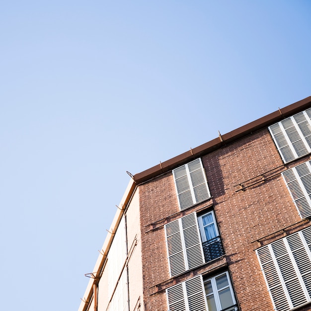 Niedrige Winkelsicht eines Gebäudes mit Fenstern gegen blauen Himmel
