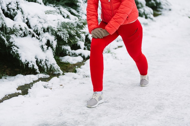 Niedriger Abschnitt des weiblichen Athleten trainierend auf Schnee