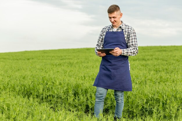 Niedriger Winkelmann am Bauernhof mit Tablette