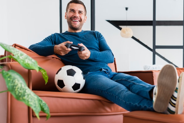 Niedriger Winkelmann auf der Couch, die Spiele spielt