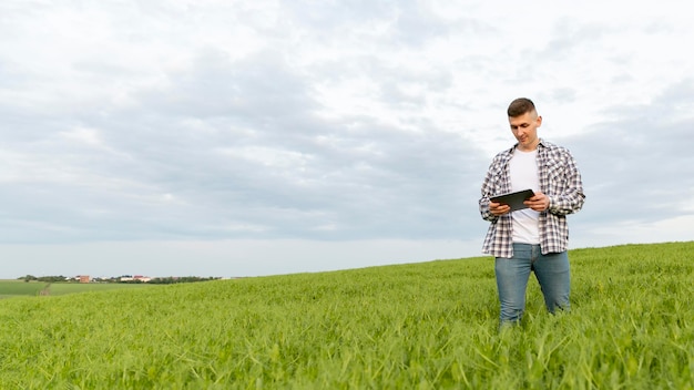 Niedriger Winkelmann mit Tablette am Bauernhof