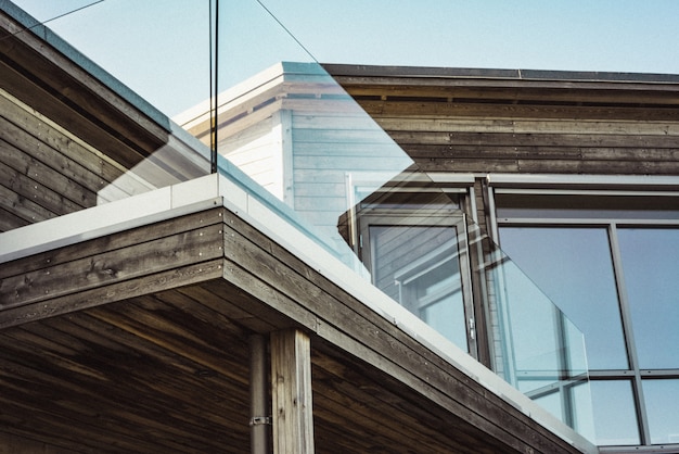 Niedriger Winkelschuss eines modernen Holzhauses mit Glasterrassenrändern