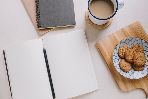 Notebook in der Nähe von Kaffee und Kekse