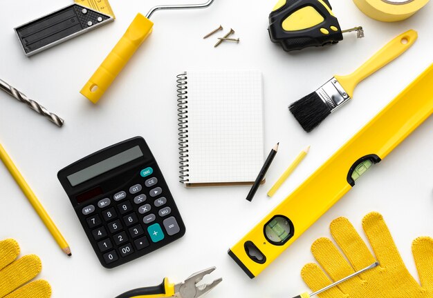 Notizblock umgeben von gelben Werkzeugen und Handschuhen