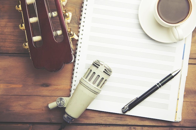Notizbuch, gitarre, kaffee, stift und mikrofon