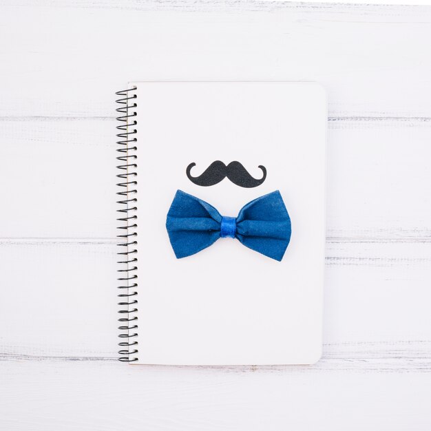 Notizbuch mit dekorativem Schnurrbart und Fliege