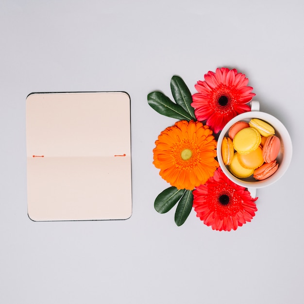 Kostenloses Foto notizbuch mit kleinen keksen und blumen auf tabelle