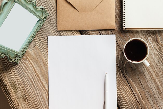 Notizbuch, Papier, Kaffeetasse und Umschlag mit altem Vintage-Bilderrahmen