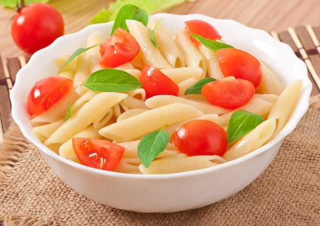 Nudelsalat mit Kirschtomaten und frischen Basilikumblättern