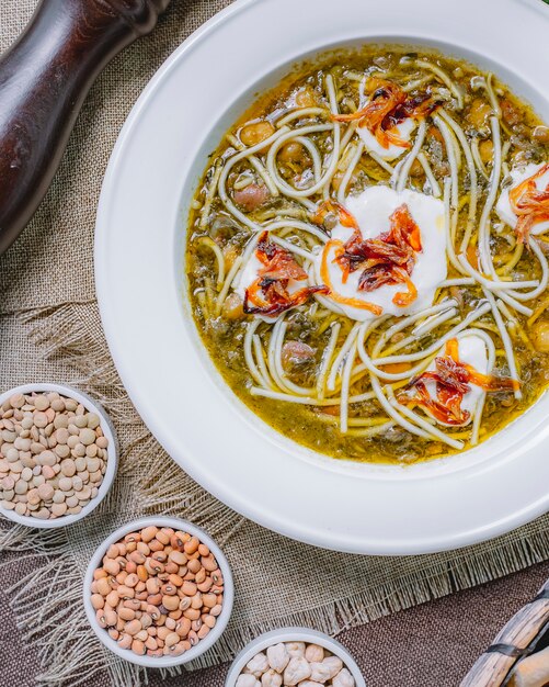 Kostenloses Foto nudelsuppe von oben mit saurer sahne